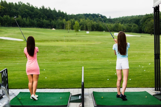 Free photo back view of casual girls at a golf field