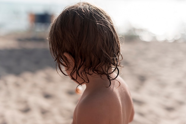 Vista posteriore stretta di un bambino in spiaggia