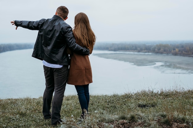 Back view of couple admiring the lake view with copy space