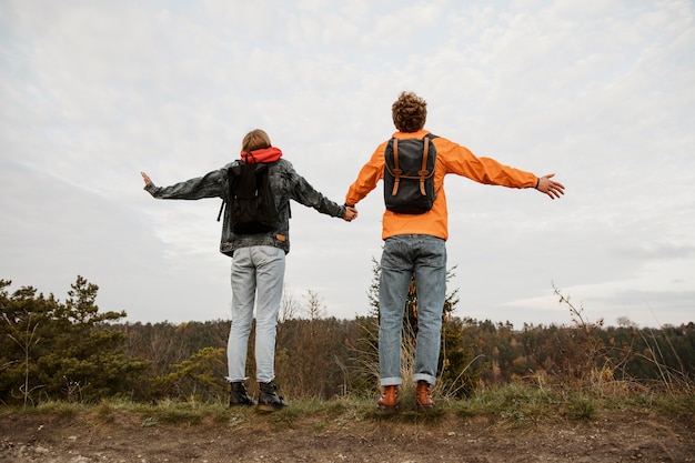 Free photo back view of couple enjoying the view while on a road trip