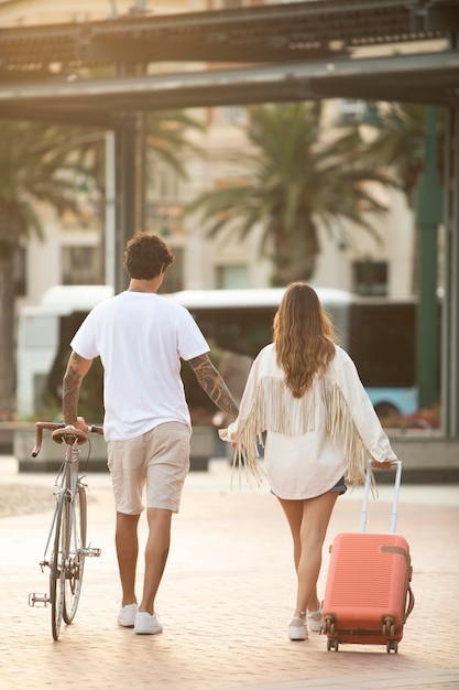 Free photo back view couple holding hands while traveling