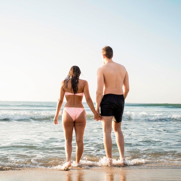 Free photo back view couple holding hands