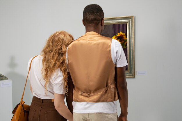 Back view couple looking at painting