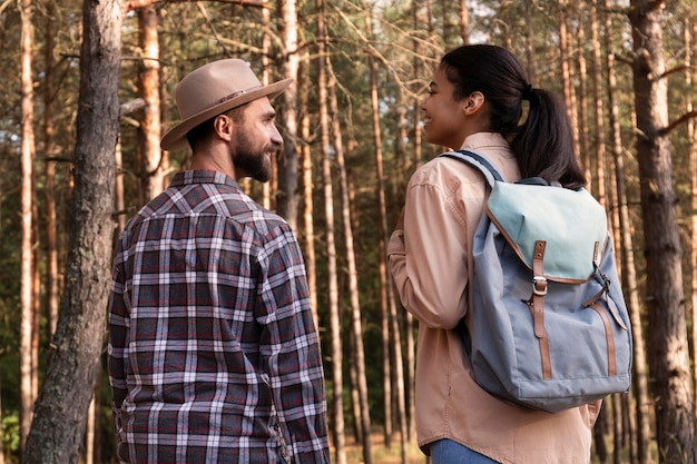 Free photo back view couple taking a walk in the forest