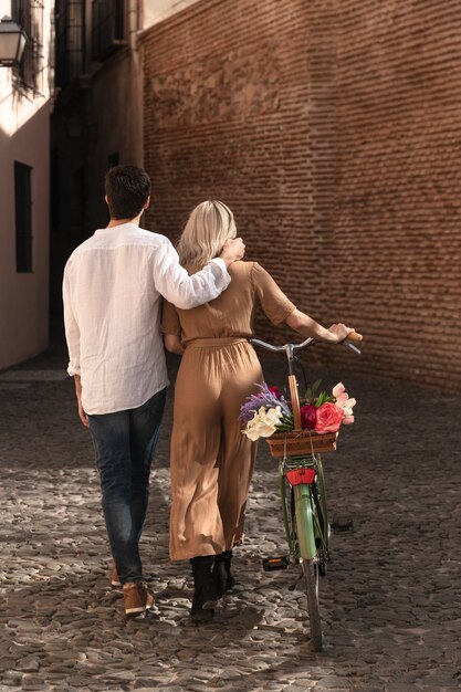 Back view of couple taking a walk with bicycle