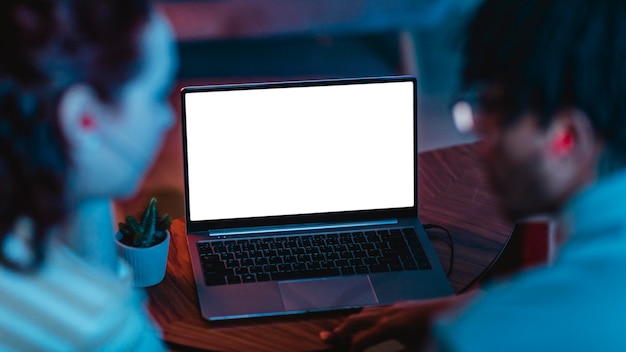 Free photo back view of couple using laptop and earphones together at home