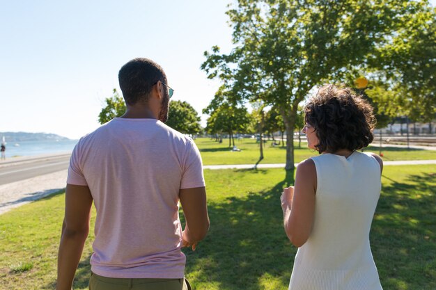 公園を歩いているカップルの背面図