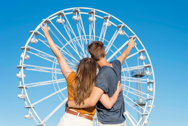 Back view couple watching a fun wheel