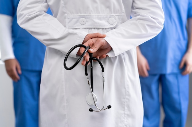 Back view doctor holding stethoscope