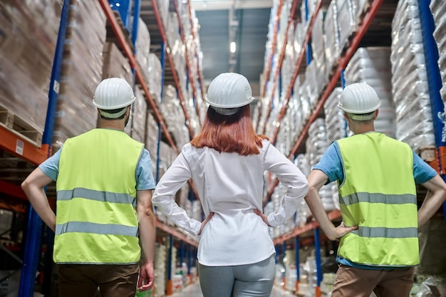 Back view of female leader and two men in overalls