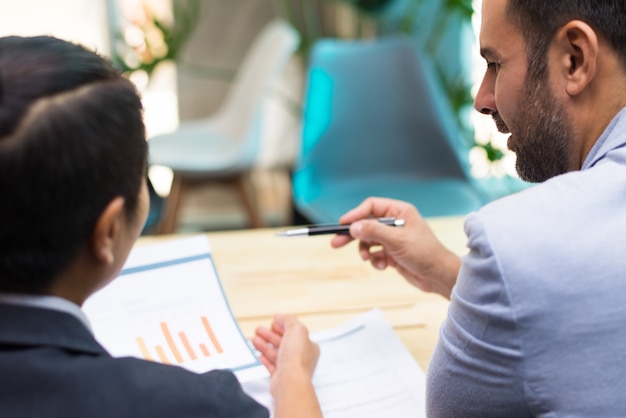 Back view of financial experts working together in office