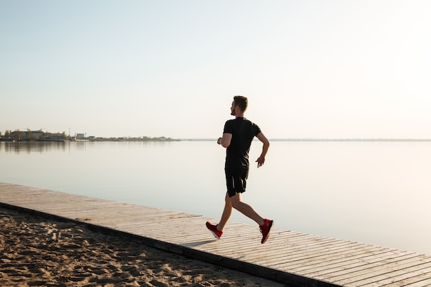 Back view full length portrait of a healthy sportsman running