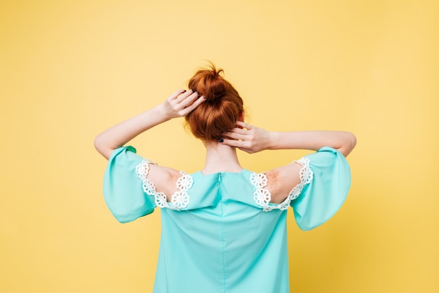 Free photo back view of ginger woman in dress posing