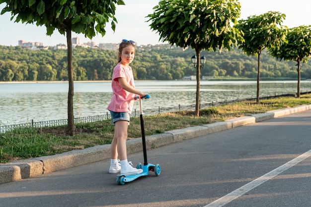 Free photo back view of girl riding blue scooter