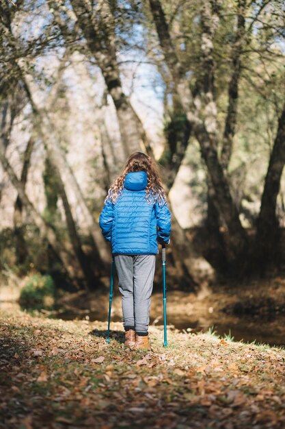 Back view girl walking in forest