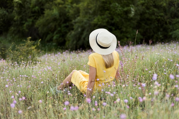 Back view girl with hat relaxing outdoors