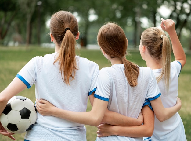 Foto gratuita ragazze di vista posteriore che si tengono l'un l'altro