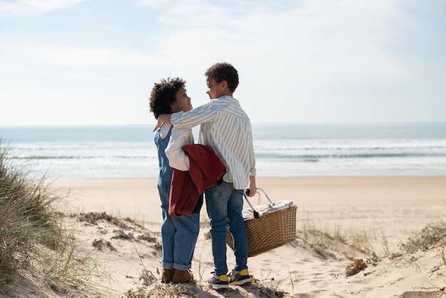 Back view of happy African American children. Brother and sister in casual clothes looking at each other, hugging. Portrait, family, childhood concept