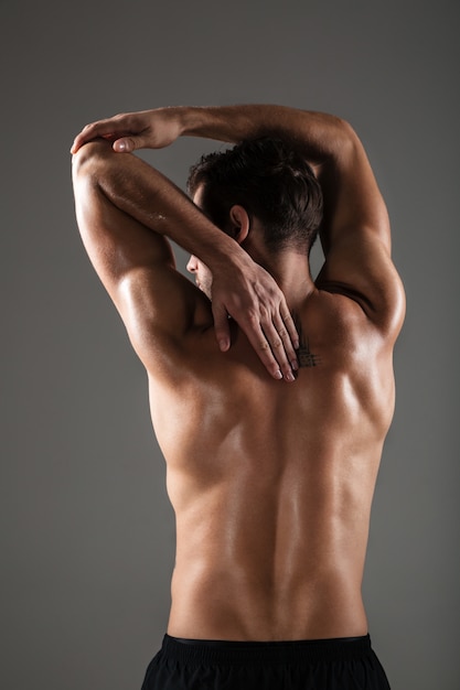 Back view image of young sports man posing