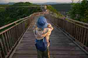 Foto gratuita ragazzo vista posteriore che esplora l'ambiente naturale