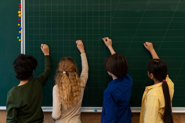 Back view kids writing on board