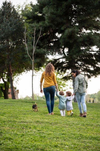 Back view of lgbt mothers outside in the park with their children