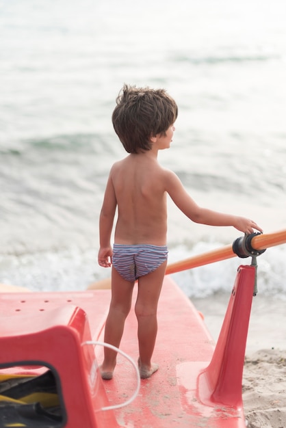 Back view of a little boy on a paddle board