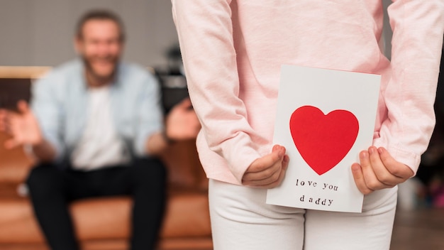 Foto gratuita vista posteriore della bambina che dà la carta del padre per la festa del papà