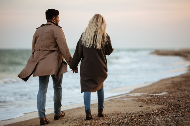 Back view of a lovely couple holding hands