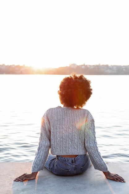 天気の良い日を楽しんでいる素敵な女性の背面図