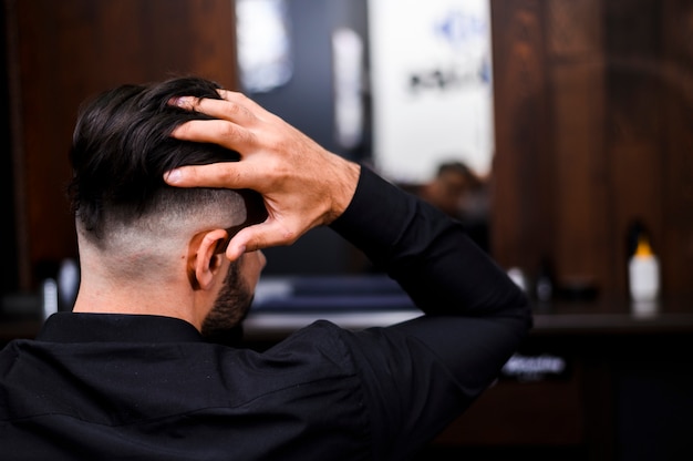 Back view of man arranging his hair