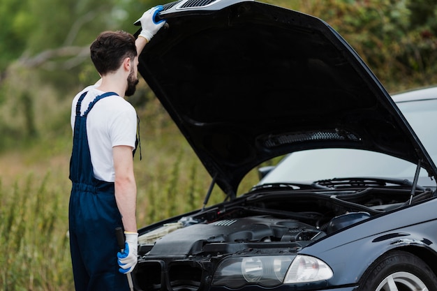 Back view of man checking engine