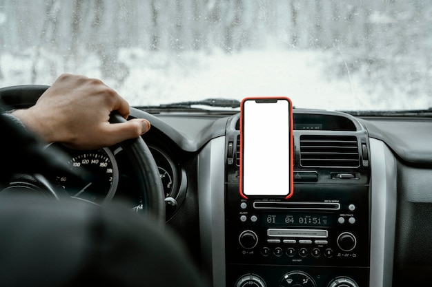 スマートフォンでロードトリップで車を運転する男の背面図
