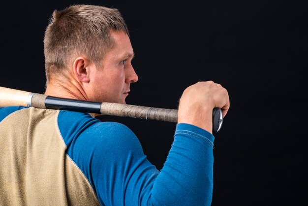 Back view of man holding baseball bat