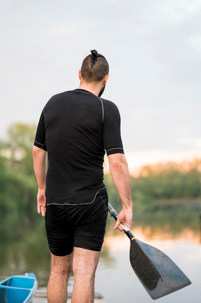 Back view man holding oar