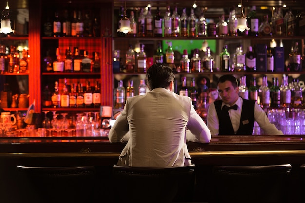 Punto di vista posteriore di un uomo che ordina bevanda a un barista