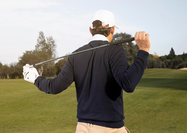 Foto gratuita vista posteriore dell'uomo che gioca a golf sul campo