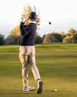 Free photo back view of man playing on the grassy golf field