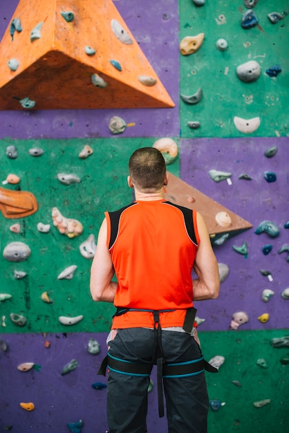 Back view man preparing climbing wall