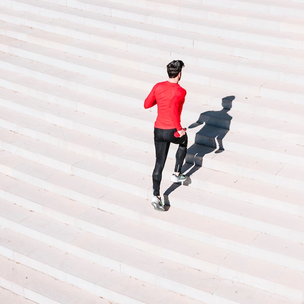 Vista posteriore uomo che corre al piano di sopra