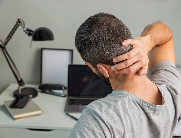 Back view of man stretching while working from home