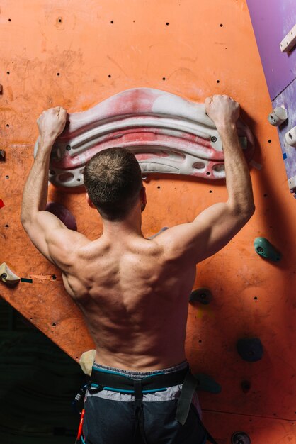 Back view man training on wall