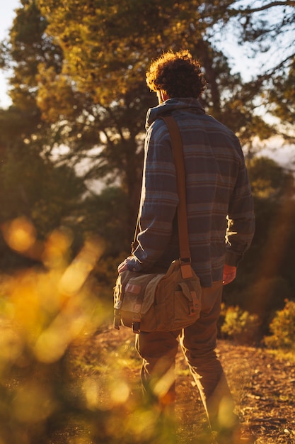 Free photo back view man walking in countryside