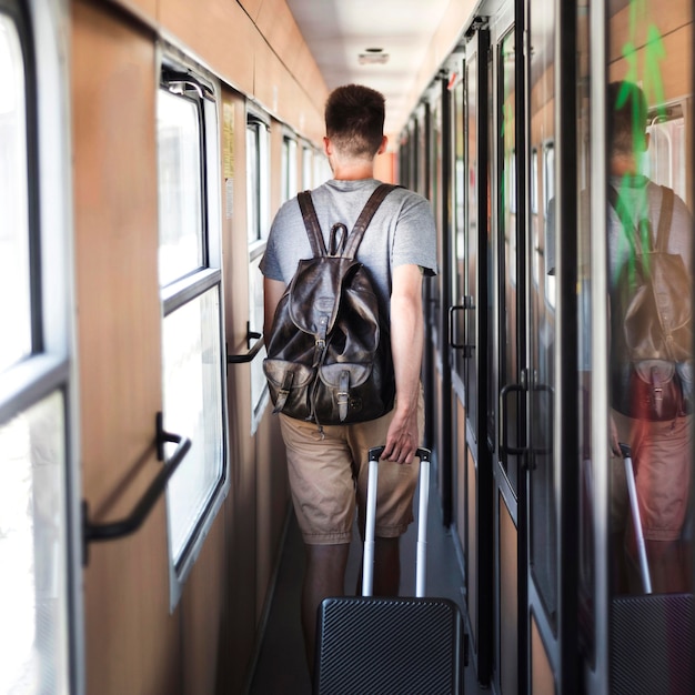 電車の中を歩いている男性の背面図