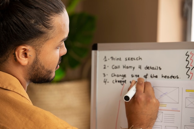 Free photo back view man writing on white board