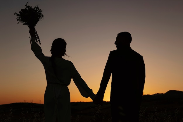 Free photo back view married couple holding hands