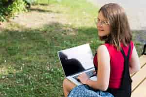 Foto gratuita colpo medio di vista posteriore della ragazza della scuola che per mezzo del computer portatile