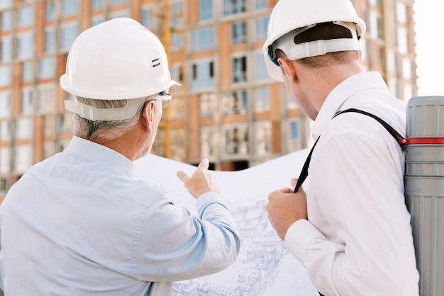 Back view men looking at building design