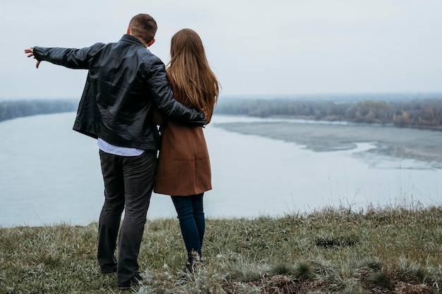 無料写真 コピースペースで湖の景色を眺めるカップルの背面図