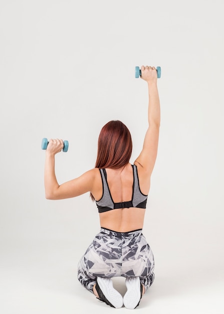 Бесплатное фото Вид сзади женщины в спортивную тренировку с весами